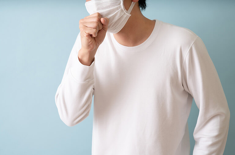 咳き込んでいるマスクをした男性